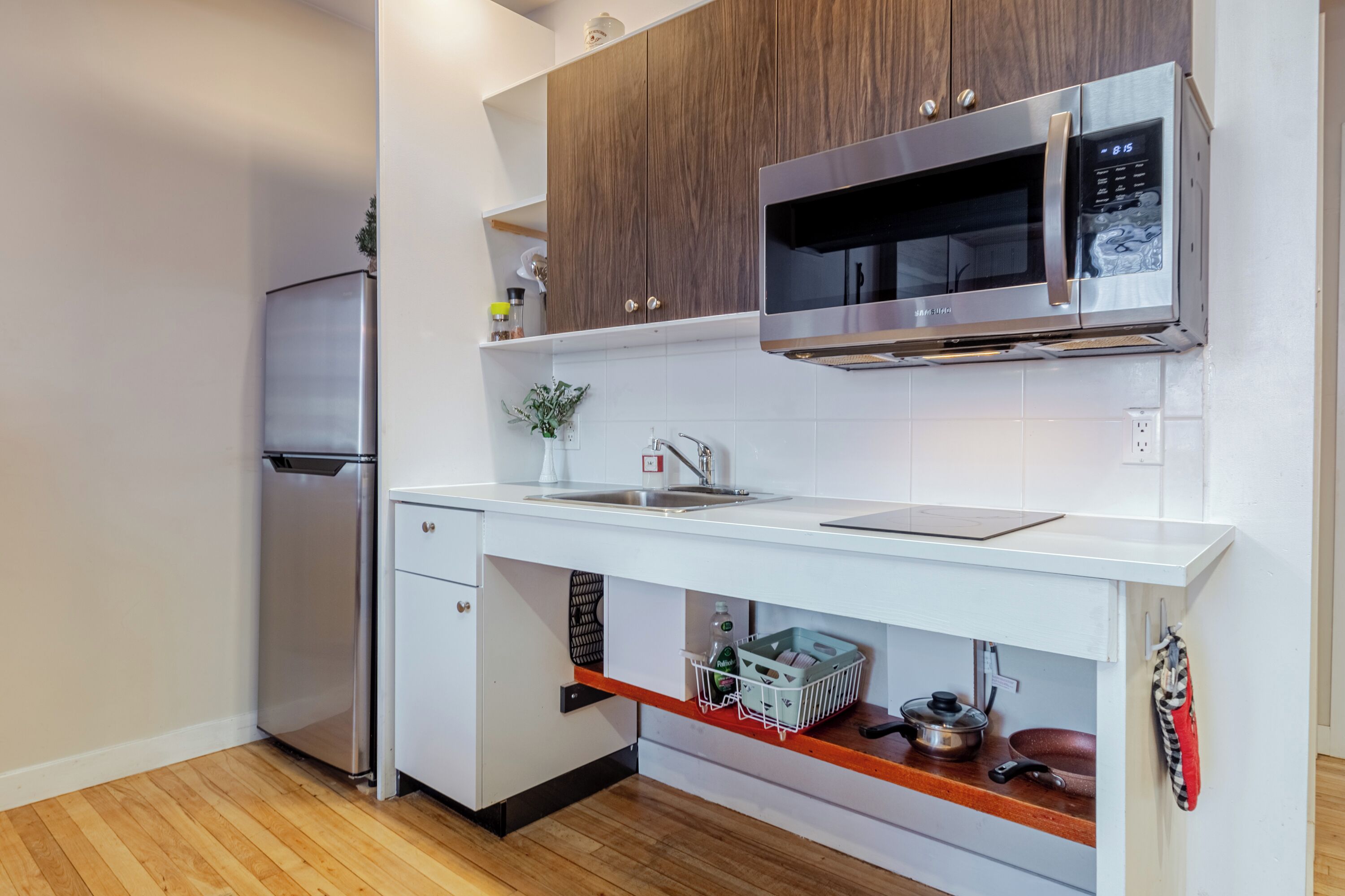 Cocina moderna con refrigerador, microondas y horno de acero inoxidable.