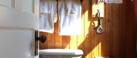 A bathroom with a toilet, a sink, and a shower area.