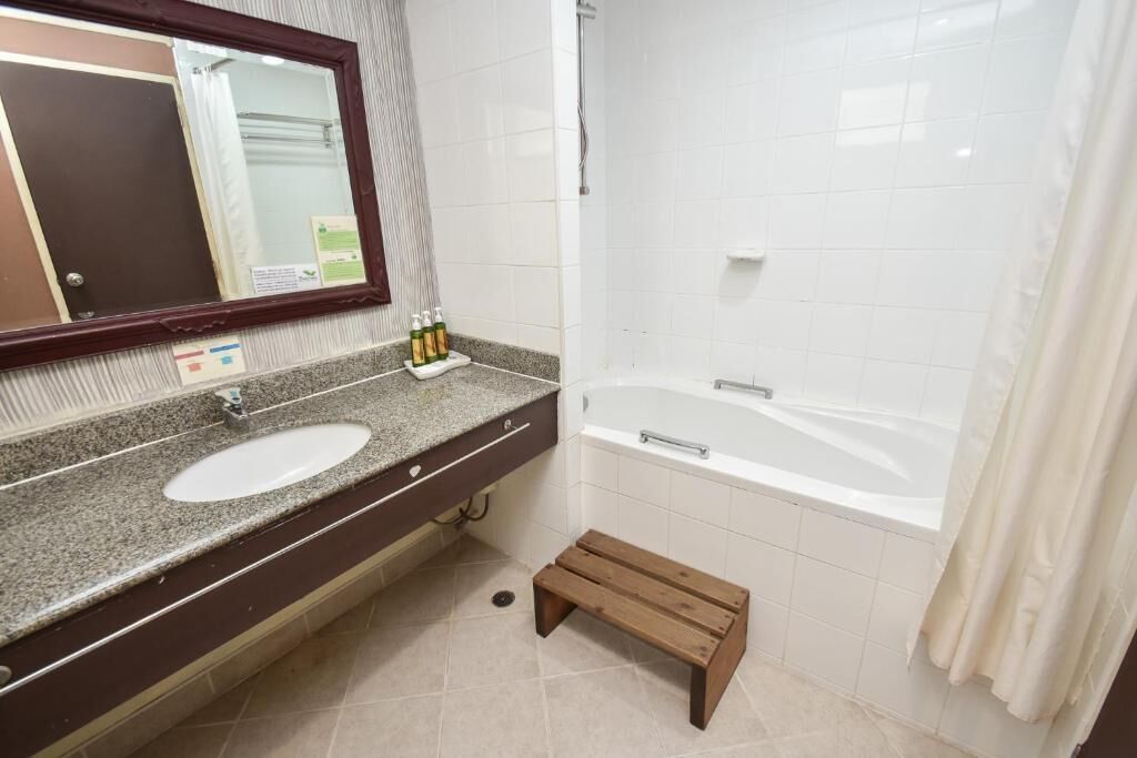 Ein Badezimmer mit Waschbecken, Spiegel und Badewanne.