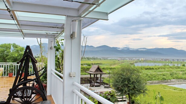 A covered outdoor area with a rustic wooden bench, a gazebo, and a view of a river and mountains. - Beautiful Ilan Resort (Dongshan)