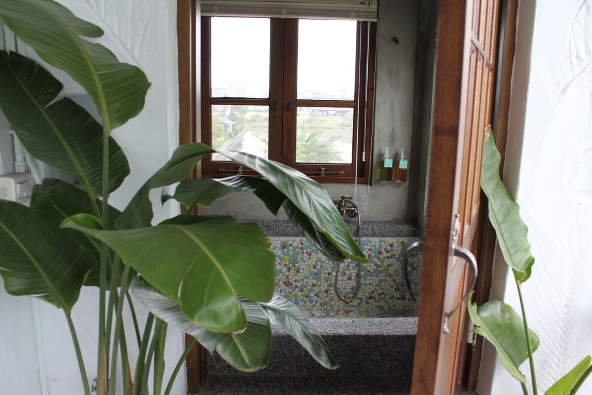 Un baño con ducha, ventana y suelo de baldosas.