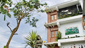 A building with a statue in front, a birdhouse on the balcony, and a painting on the wall. - Beautiful Ilan Resort (Dongshan)