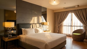 A hotel room with a large bed, two bedside lamps, a wicker chair, and a large window with curtains. - Imperial Heritage Hotel Melaka (Malacca City)