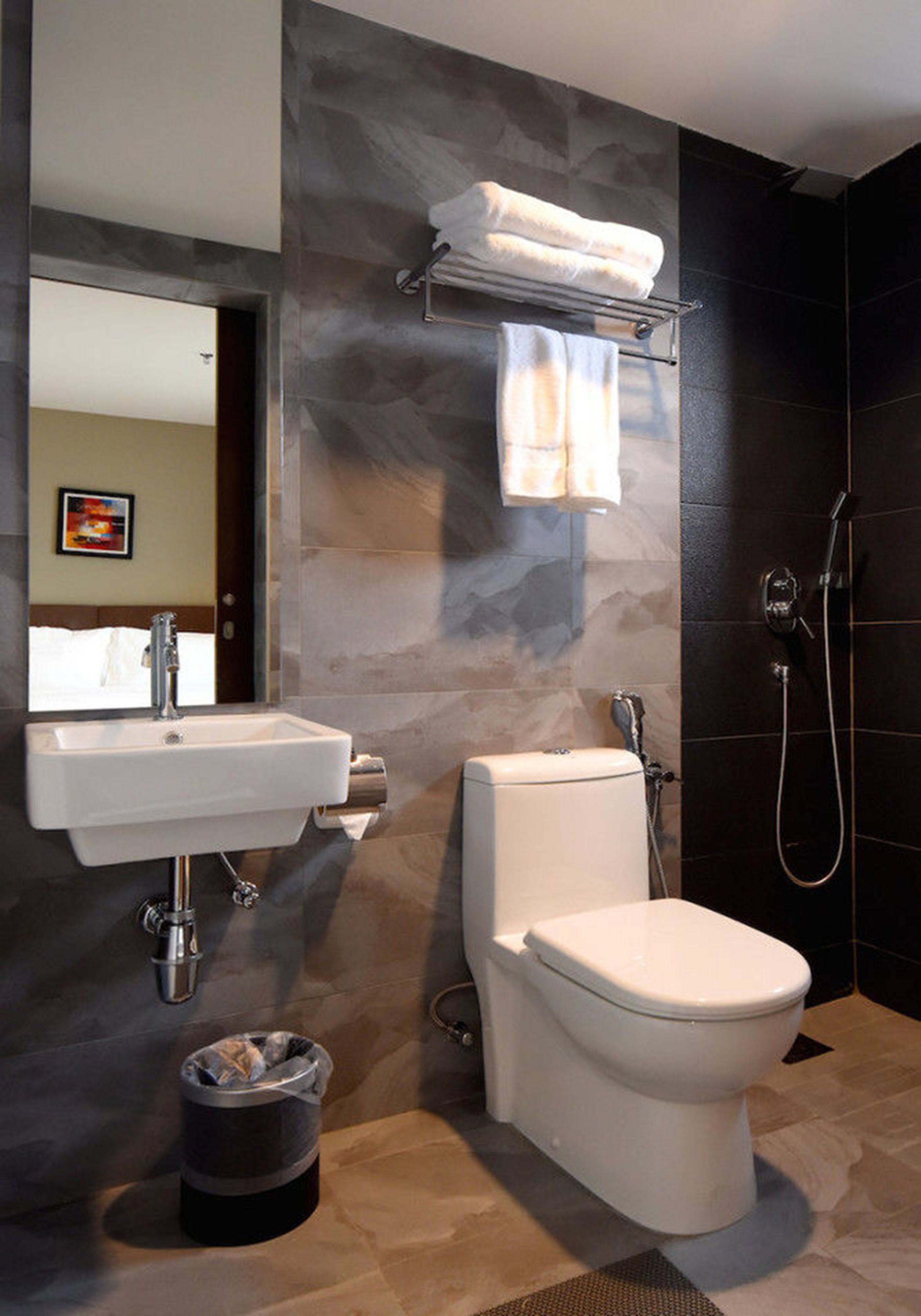 Un baño moderno con lavamanos, inodoro y ducha blancos.