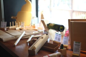 Uma mesa de madeira com diversos objetos, incluindo uma garrafa, caixas e etiquetas.