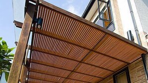 A wooden deck with a pergola, a brick wall, and a window. - Cypress House (Ji'an)