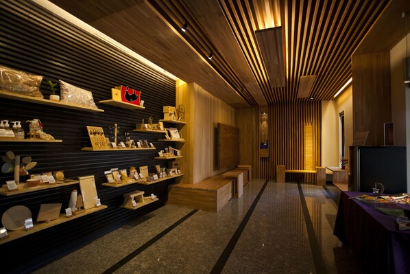 A modern interior with wooden shelves displaying various items, a bench, and a table with a television.