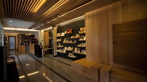 A modern interior with wooden paneling, a reception desk, and shelves displaying various items. - Cypress House (Ji'an)