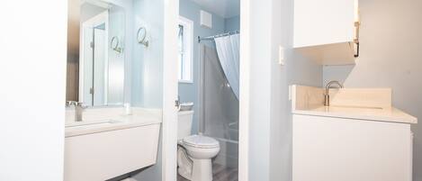 Une salle de bain moderne équipée de toilettes, d’un lavabo et d’une zone douche.