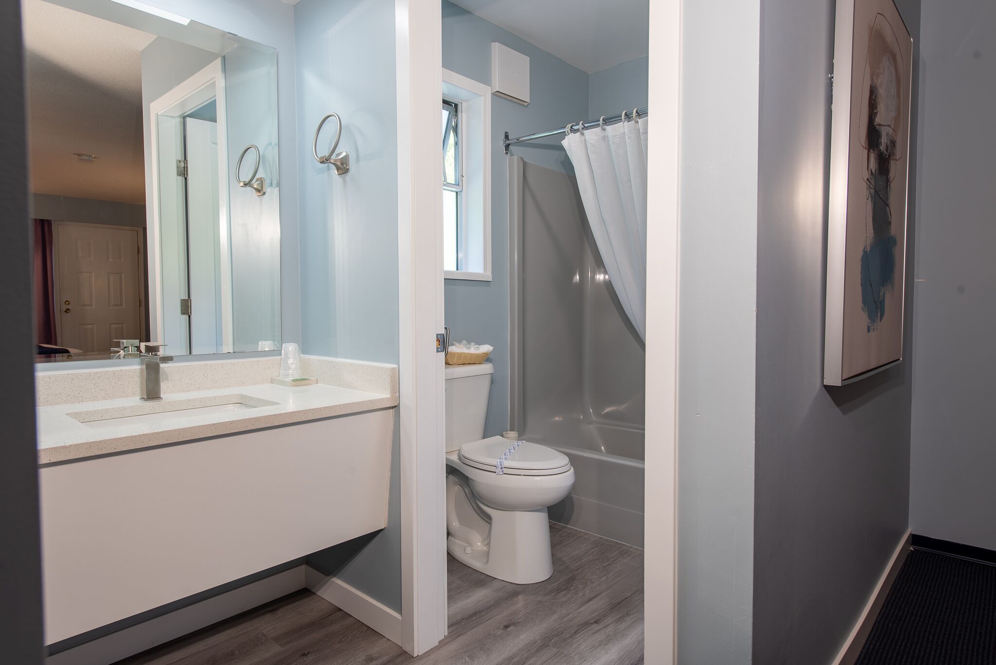 A bathroom with a white sink, toilet, and shower curtain.