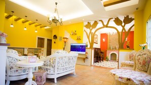 A brightly colored living room with floral upholstery, a fireplace, and a television. - Belle Garden Yillan Villa (Dongshan)