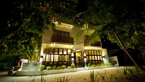 A two-story hotel with a balcony on the second floor, surrounded by lush greenery. - Boutique Beach (Dhigurah)