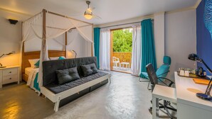 A bedroom with a four-poster bed, a desk with a chair, a nightstand, and a view of the outside balcony. - Boutique Beach (Dhigurah)