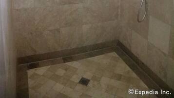 Une salle de bain avec une douche, une fenêtre et des murs carrelés.
