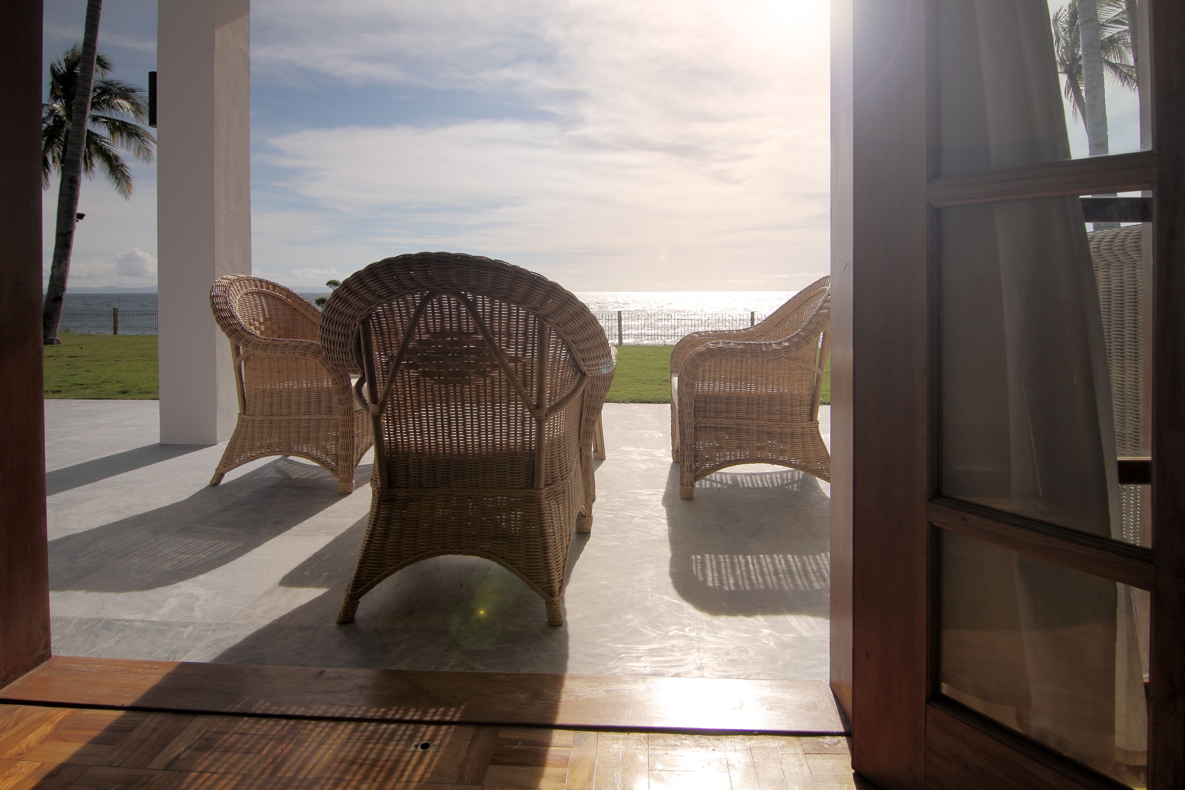 Una habitación con muebles de mimbre y vista al mar.