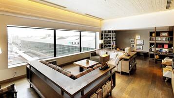 A modern living room with a sectional sofa, a coffee table, and a bookshelf.