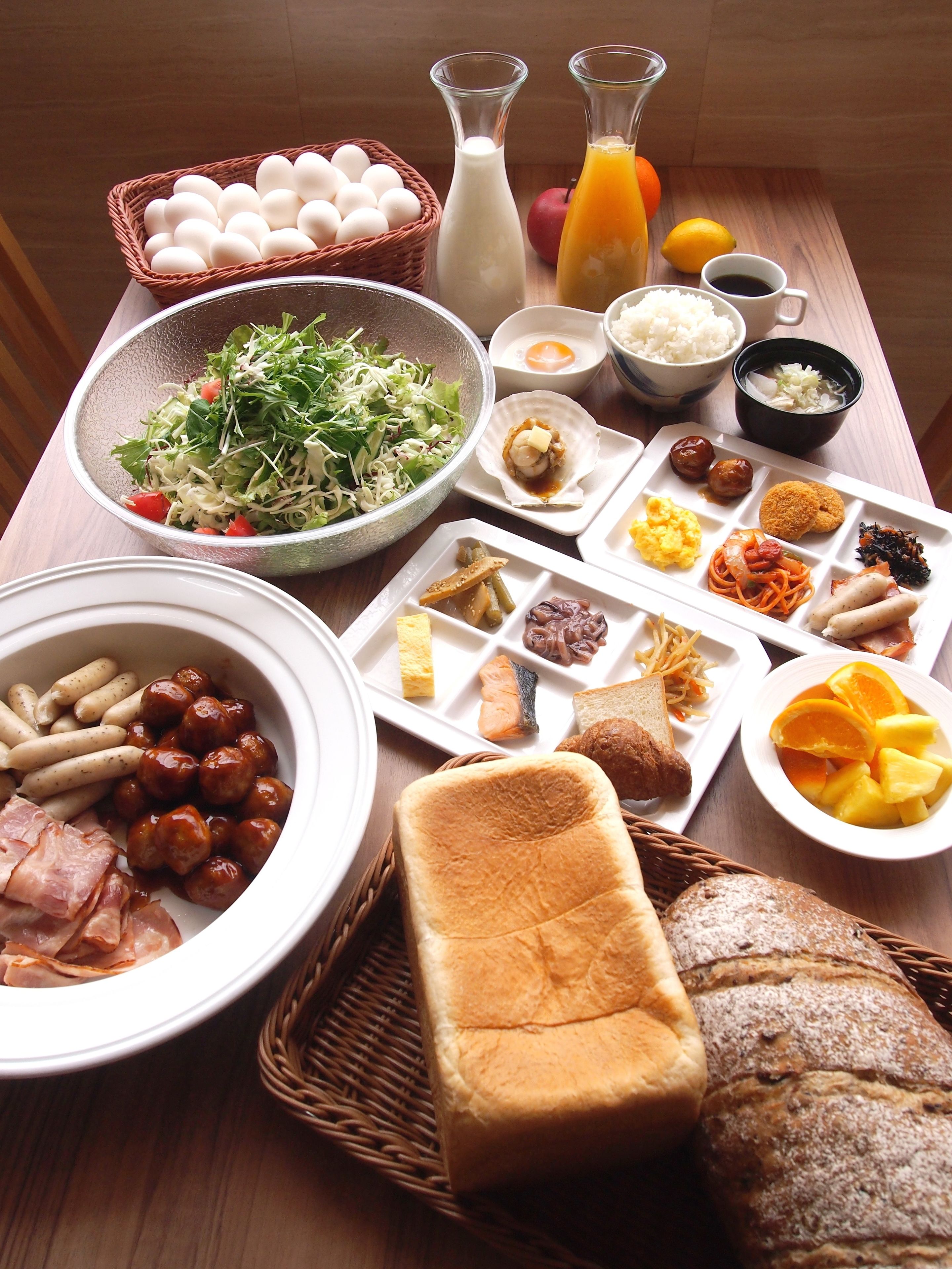 A breakfast spread with various dishes including eggs, toast, and fruit.