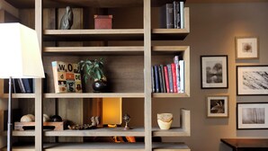 A wooden bookshelf with books, decorative items, and a small table.