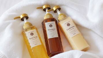 Three bottles of body soap on a white towel.