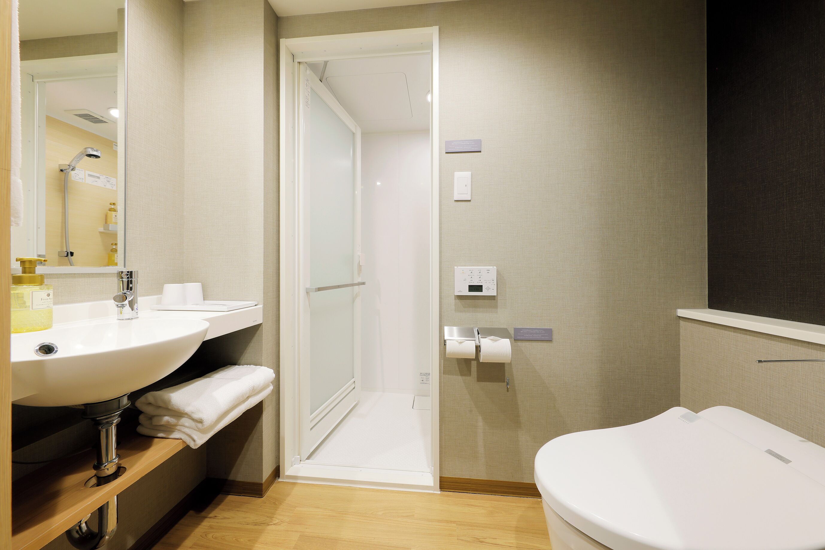 A modern bathroom with a sink, toilet, and shower area.
