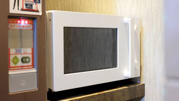 A white microwave oven mounted on a wooden shelf.