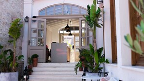 A courtyard with a seating area, potted plants, and a view into the building. - Viento Hotel Alacati - Special Class (Cesme)