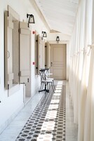 Un pasillo con puertas, una mesa con sillas y un suelo estampado.