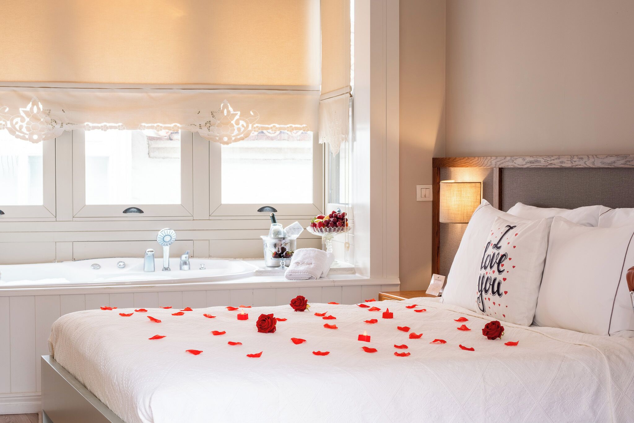 Una habitación de hotel con cama, ventana, lavamanos y mesita de noche.