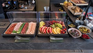 A buffet with various food items including meats, cheeses, fruits, and condiments. - VISIONAPARTMENTS Zurich Wolframplatz (Zürich)