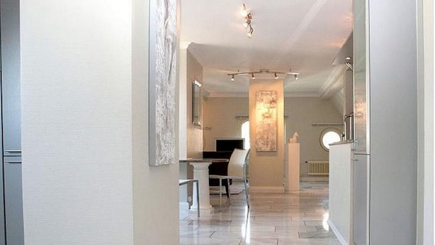 A modern interior with a hallway leading to a dining area, featuring a piano and a large artwork on the wall. - VISIONAPARTMENTS Zurich Waffenplatzstrasse (Zürich)