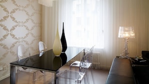 A modern living room with a glass dining table, clear chairs, a black vase, a sofa, and a floor lamp. - VISIONAPARTMENTS Zurich Waffenplatzstrasse (Zürich)
