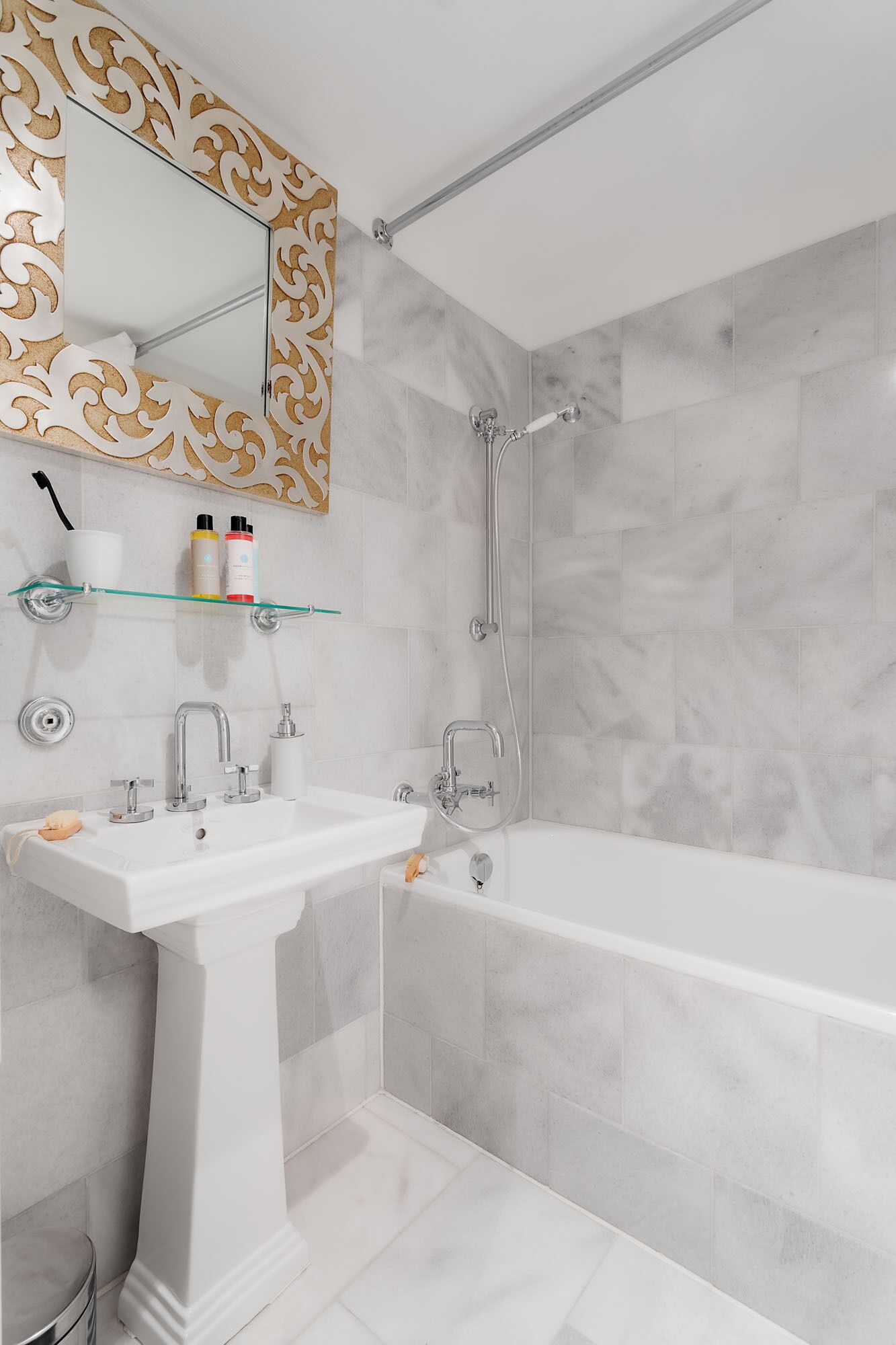 Un baño moderno con lavamanos, mueble de tocador y bañera blancos.