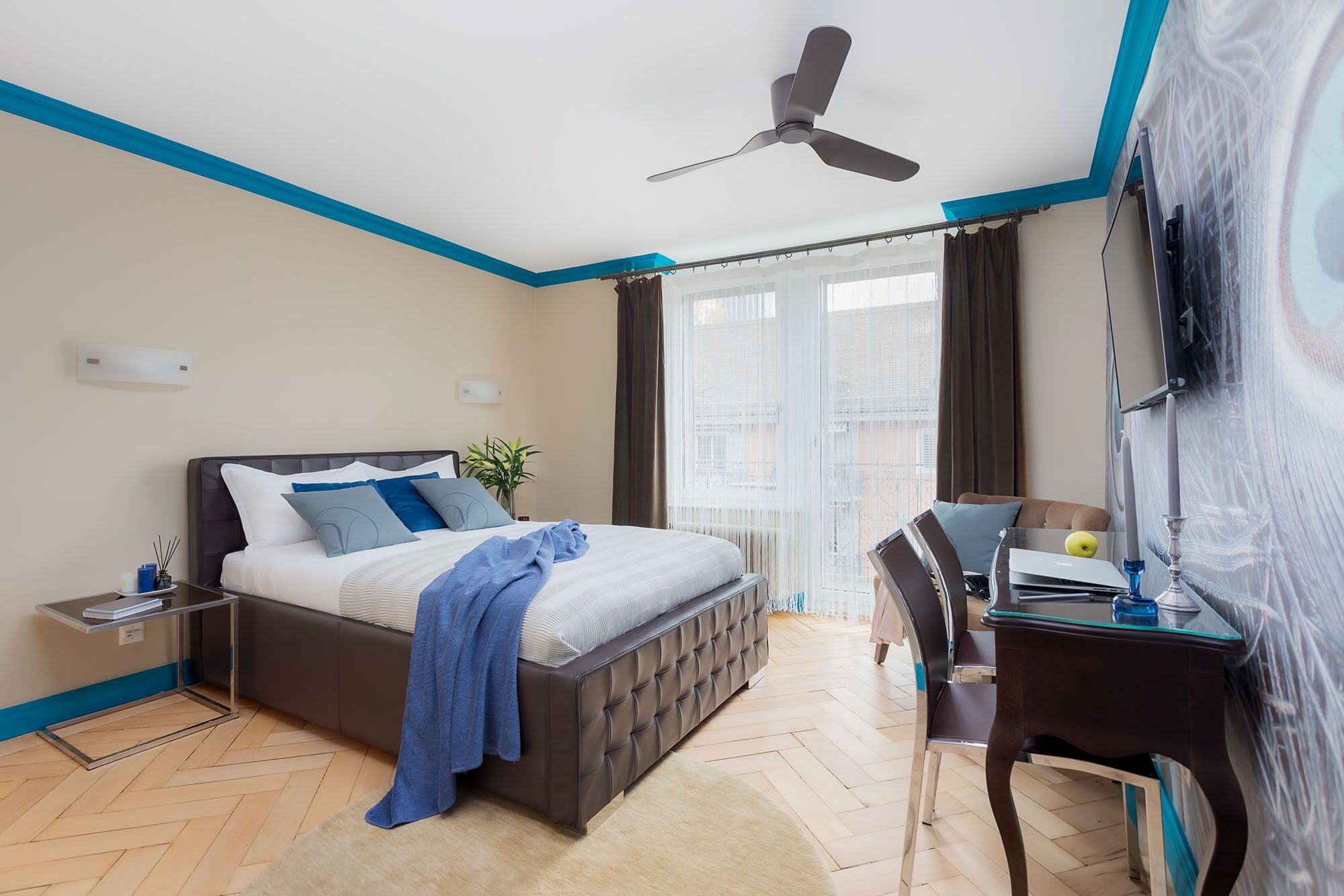 Quarto moderno com cama, mesa de cabeceira e escrivaninha com cadeira.