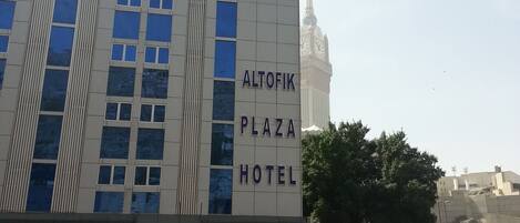 Egy épület, amelyen egy „Altofik Plaza Hotel” feliratú tábla látható, a háttérben pedig egy minaret.