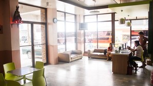 A spacious cafe with large windows, green chairs, and a wooden counter. - GV Hotel Ormoc (Ormoc)