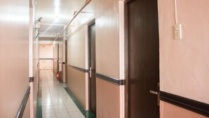 A corridor with doors, a fire extinguisher, and a number sign. - GV Hotel Ormoc (Ormoc)