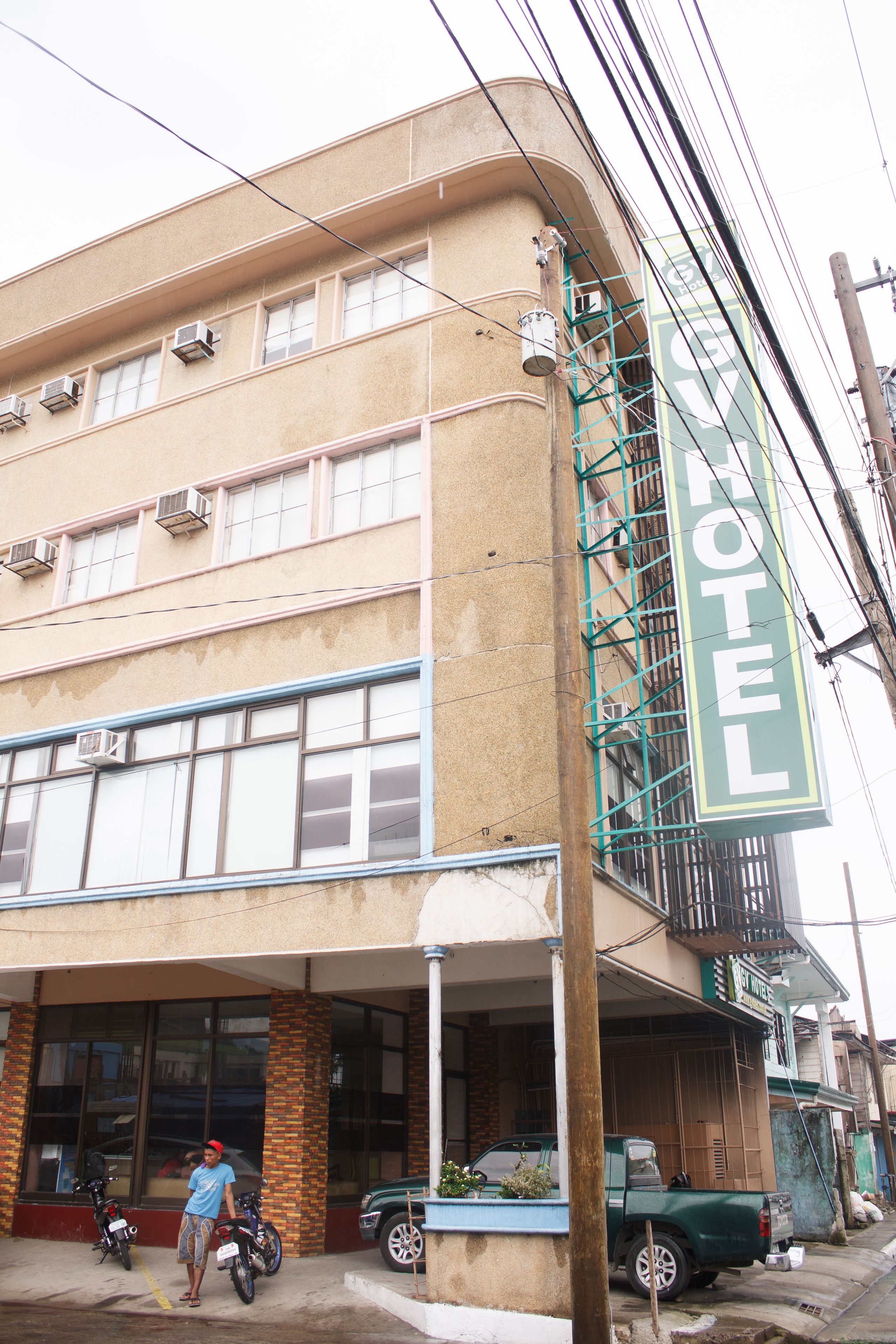 A building with a sign that reads "HOTEL" and multiple air conditioning units on the exterior.