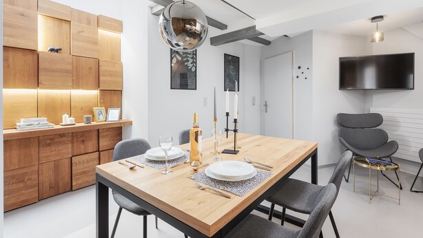 A modern dining area with a wooden table, chairs, and a pendant light. - VISIONAPARTMENTS Zurich Cramerstrasse 2-6 (Zürich)