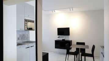 A modern kitchen with a built-in microwave and a dining area with a table and chairs.