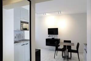 A modern kitchen with a built-in microwave and a dining area with a table and chairs.