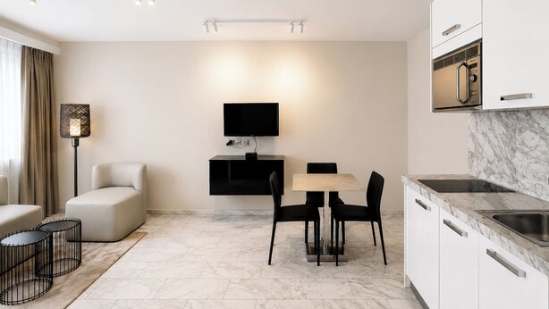 A modern kitchen with a built-in microwave, a dining area with a table and chairs, and a sofa. - VISIONAPARTMENTS Zurich Freyastraße (Zürich)