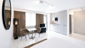 A modern hotel room with a dining area, a kitchen, and a large mirror. - VISIONAPARTMENTS Zurich Freyastraße (Zürich)