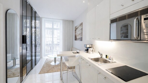 A modern kitchen with a dining area, stainless steel appliances, and a large window. - VISIONAPARTMENTS Zurich Gerechtigkeitsgasse (Zürich)