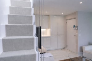 A modern interior with a staircase, a glass table, and white cabinets. - VISIONAPARTMENTS Zurich Gerechtigkeitsgasse (Zürich)