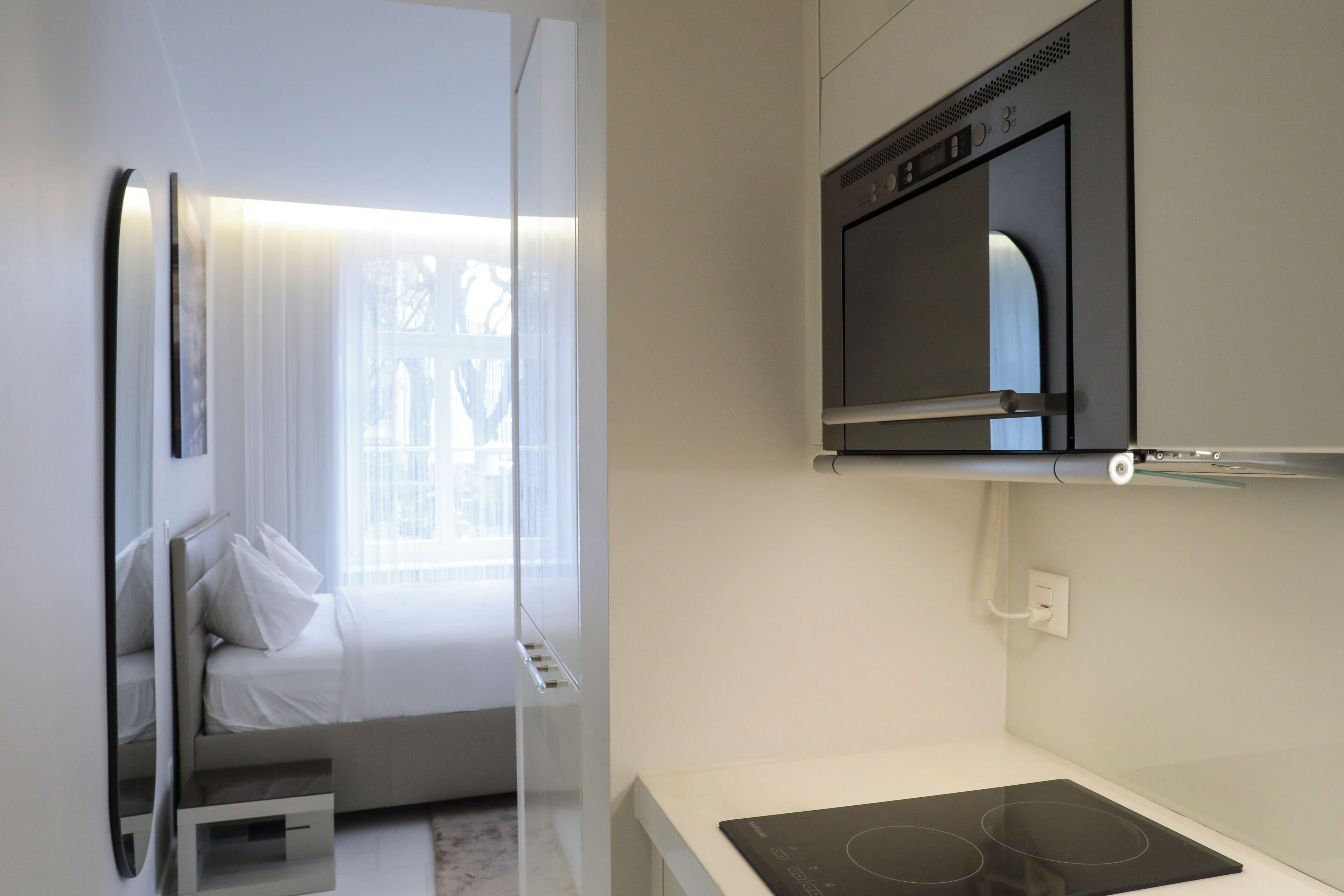 Ein modernes Hotelzimmer mit einem Bett, einem an der Wand befestigten Fernseher und einer fest eingebauten Heizung.