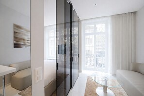 A modern living room with a glass partition, a glass table, a sofa, and a view of the city through large windows. - VISIONAPARTMENTS Zurich Gerechtigkeitsgasse (Zürich)