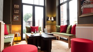 Ein modernes Wohnzimmer mit einer Holzbank, einem Tisch mit einem Laptop und einem roten Hocker.