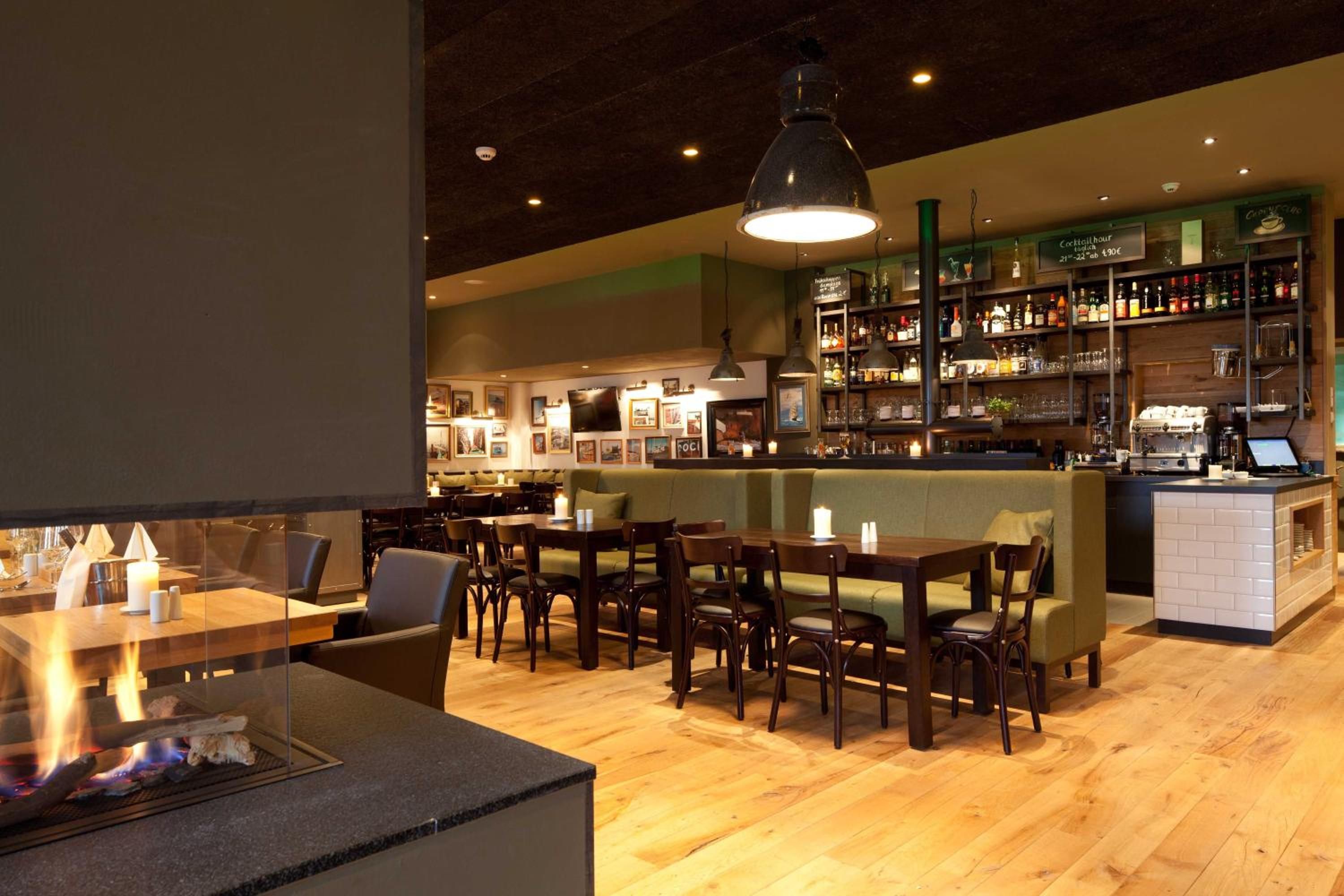 A restaurant with a bar area, wooden furniture, and a fireplace.