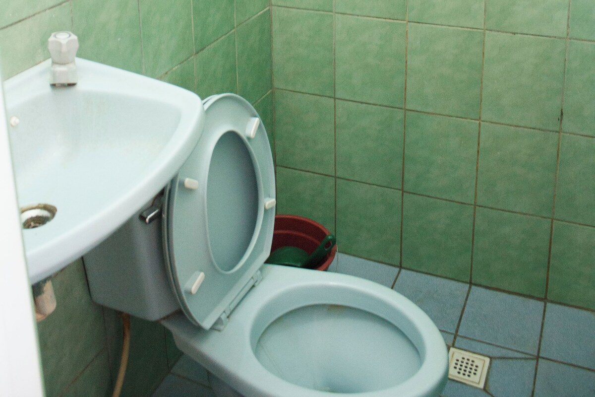 A bathroom with a toilet, sink, and shower.