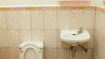 Un baño con inodoro, lavamanos y espejo.
